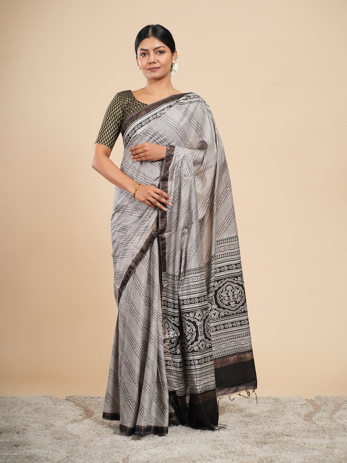 Silver grey Modal saree with Bandhni dot print and deep black border, draped for daytime wear — Koshnika